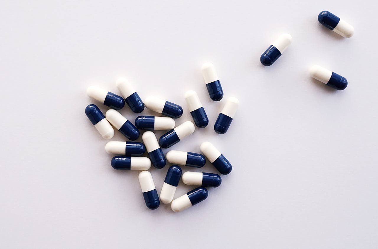 Services Flat lay of blue and white capsules arranged on a white surface, perfect for healthcare and medical themes.