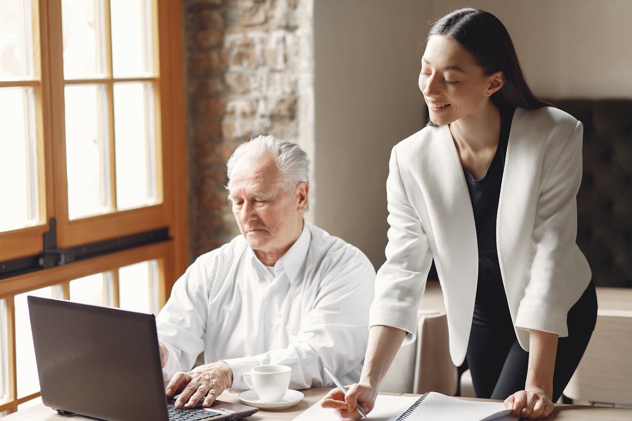 Senior businessman working with a young colleague in a modern office setting.