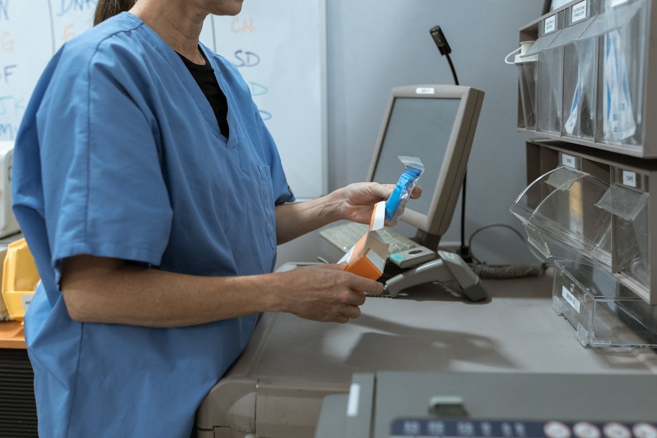 Services Healthcare worker in scrubs organizing medication in a medical facility.